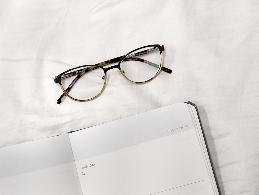 brown and black framed eyeglasses on white paper