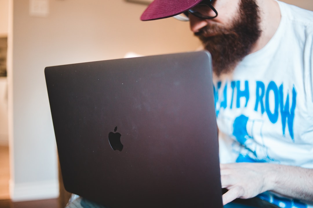 man in white shirt using black macbook