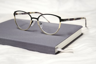 black framed eyeglasses on black book