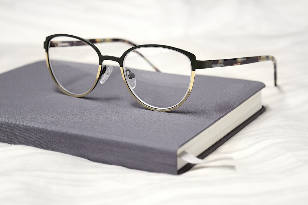 black framed eyeglasses on black book