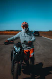 man in black jacket riding on black and orange sports bike