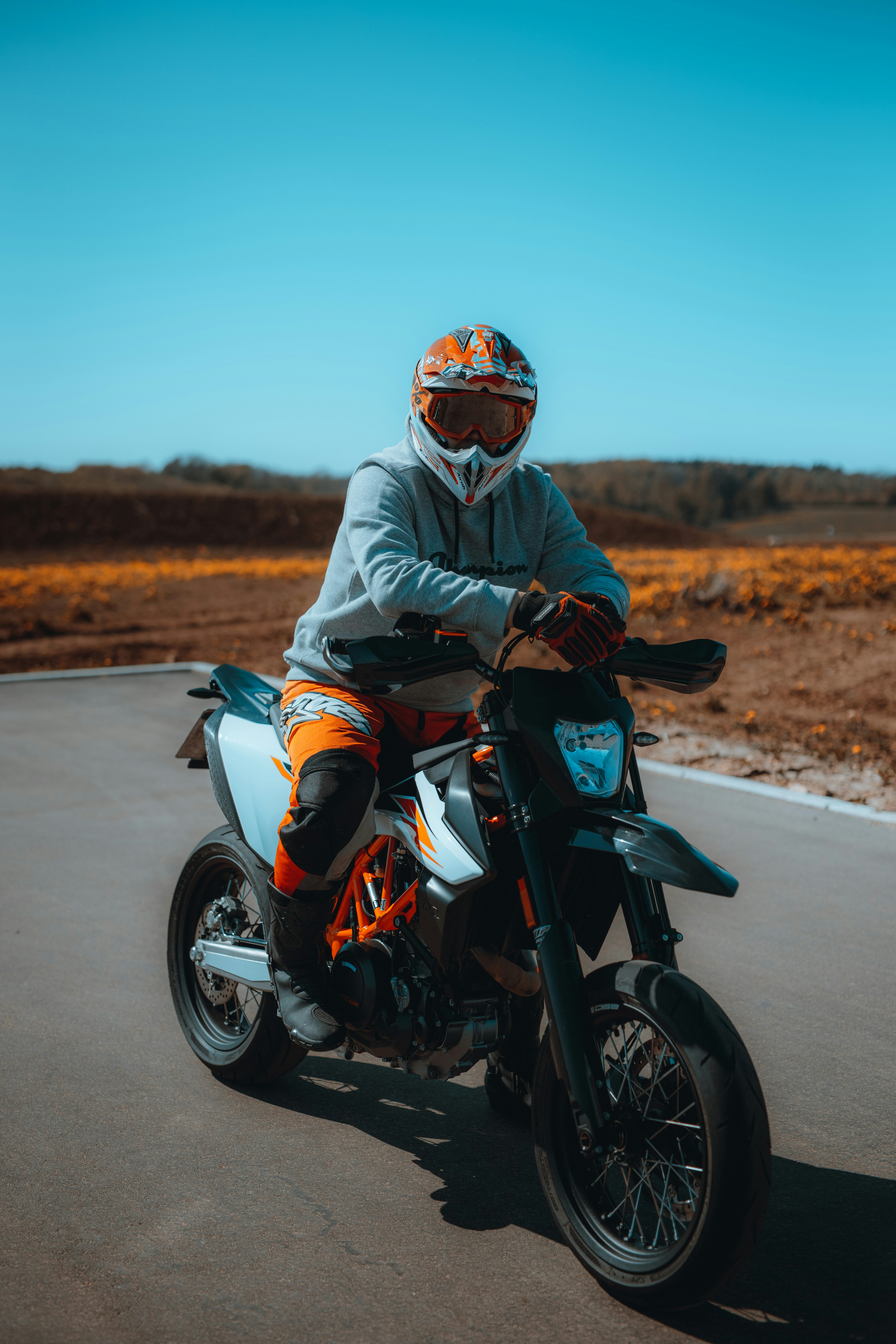 man in gray jacket riding on red and black sports bike