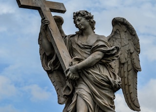 angel statue under white clouds during daytime