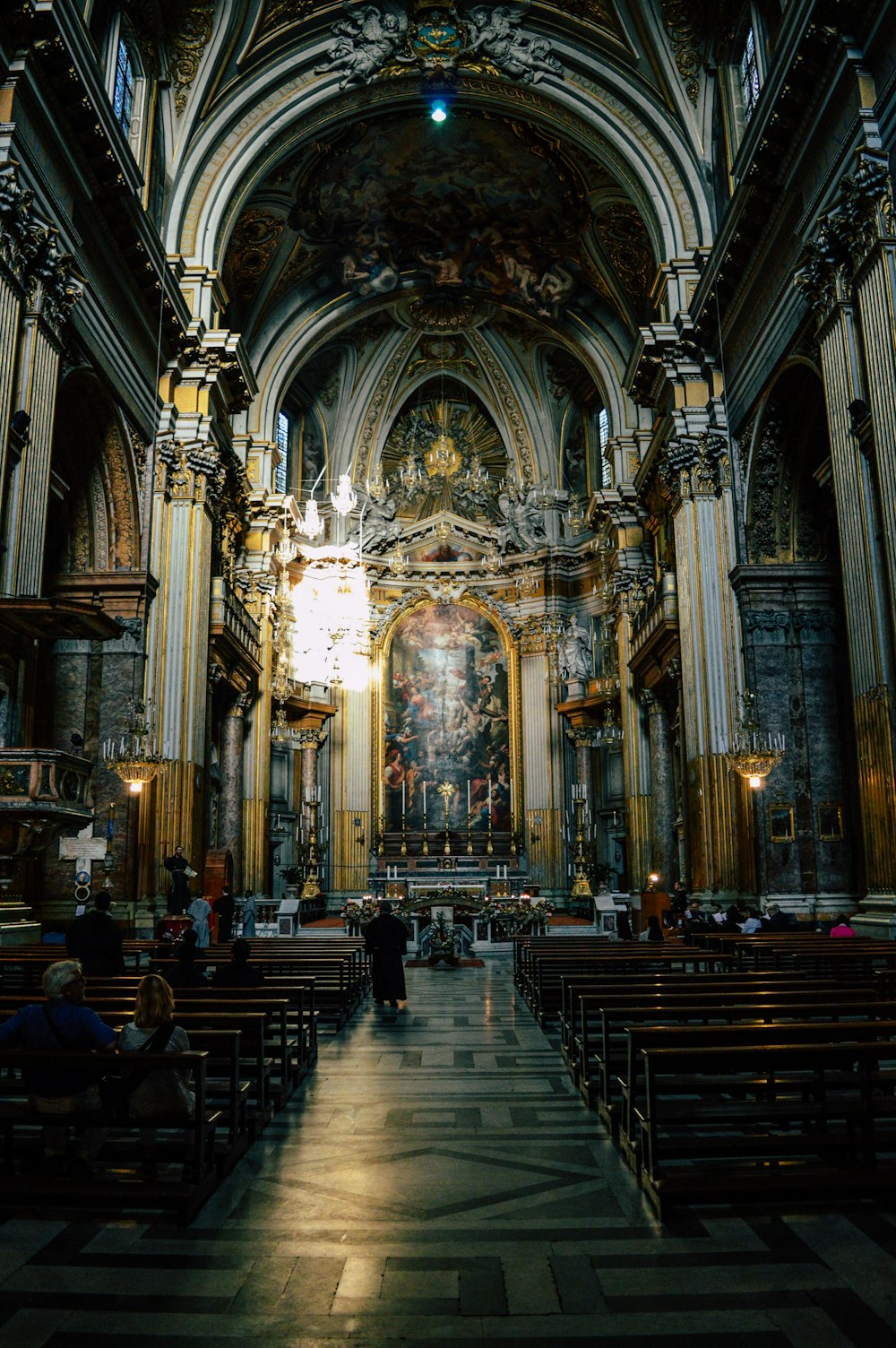 pessoas sentadas em cadeiras de madeira marrom dentro da catedral