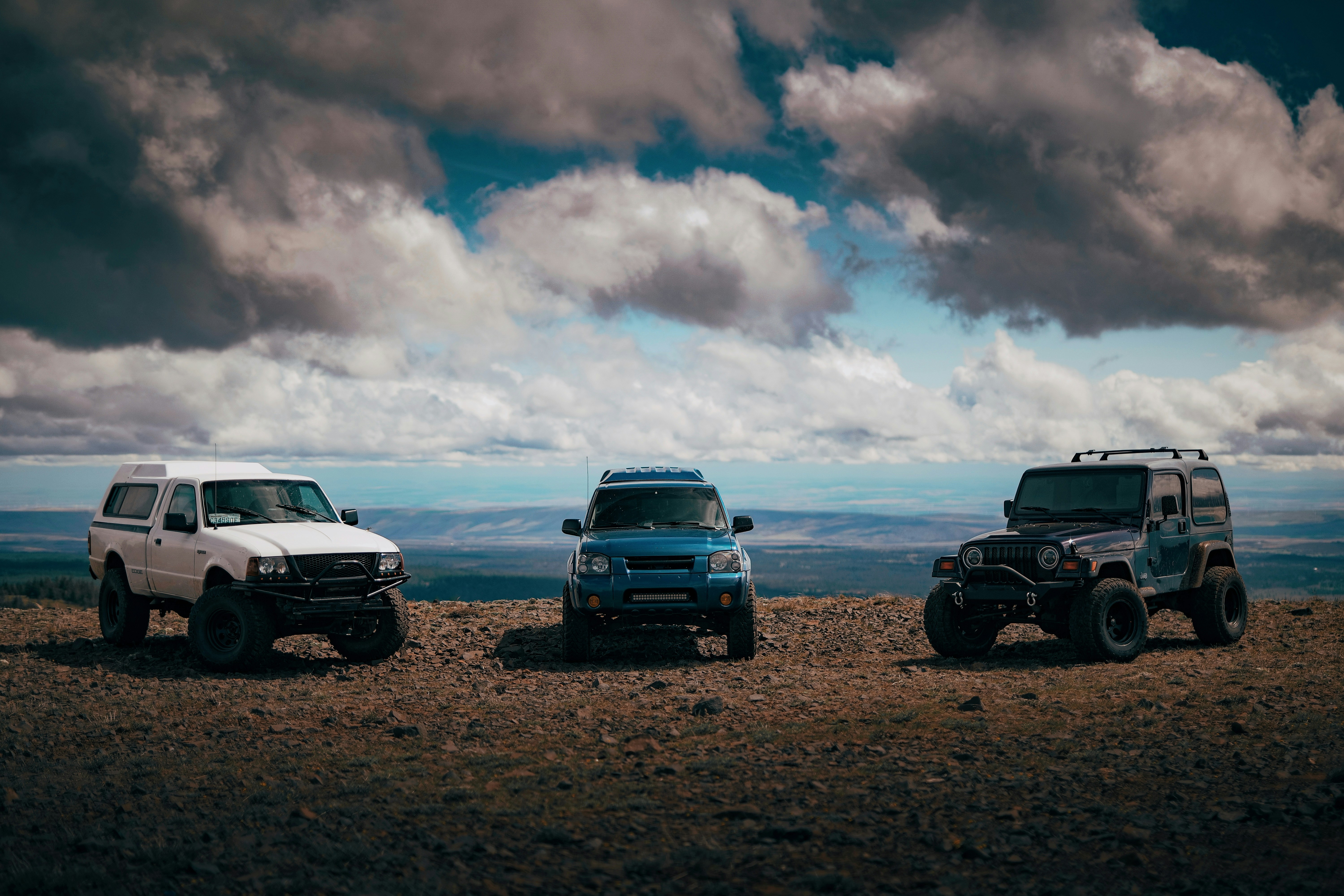 black suv on brown field under cloudy sky