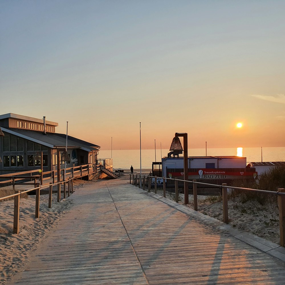 brown wooden dock on sea during sunset