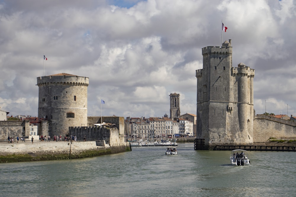 Bâtiment en béton brun près d’un plan d’eau sous un ciel nuageux pendant la journée