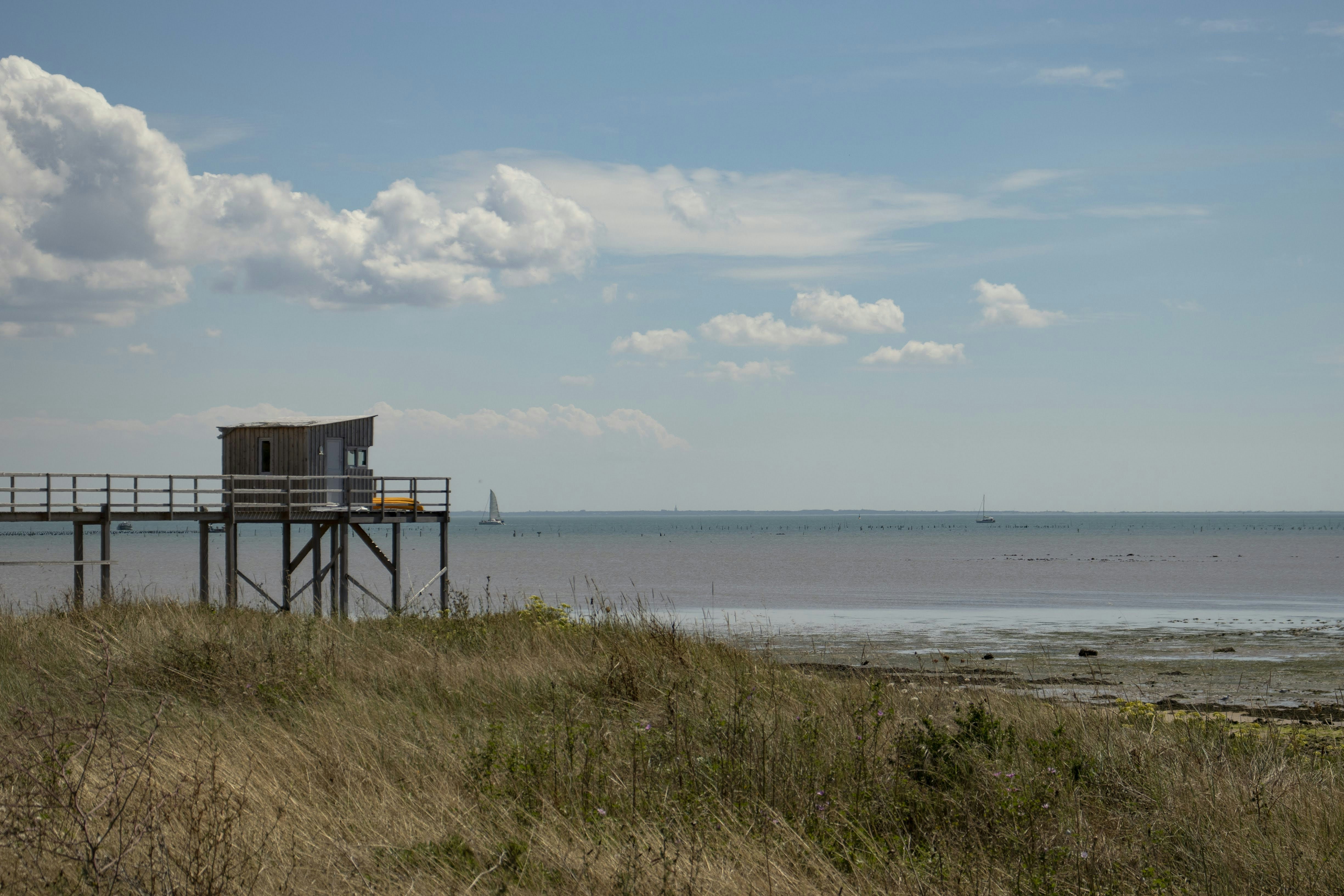 brown wooden house on seashore during daytime