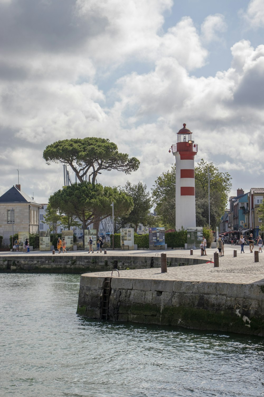 white and red lighthouse near body of water during daytime