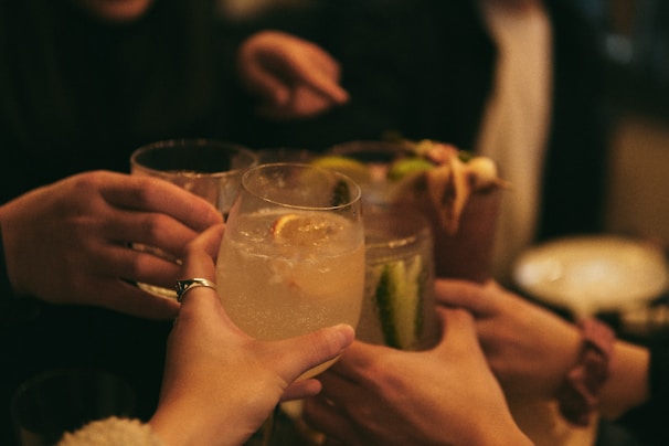 Members of the club raising glasses in a toast, dressed in dark suits in a warmly lit room.