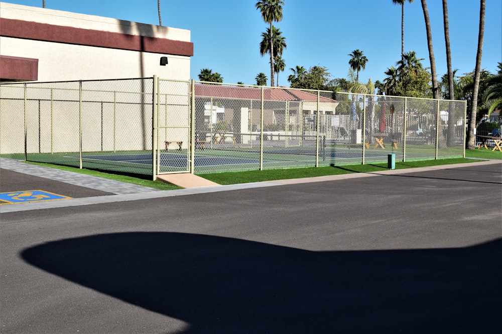 white metal fence near green grass field during daytime