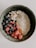 A bowl of creamy oatmeal ice cream topped with fresh berries and nuts.