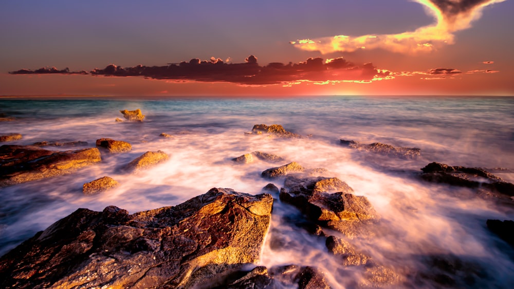 ocean waves crashing on rocks during sunset
