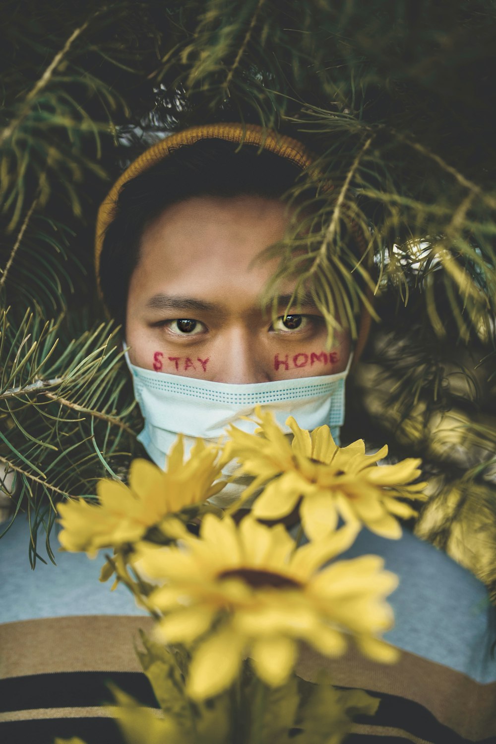 girl in white hijab standing beside yellow flowers