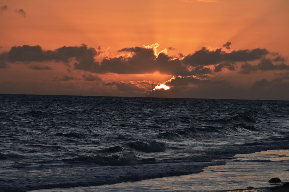 Meereswellen stürzen während des Sonnenuntergangs an Land