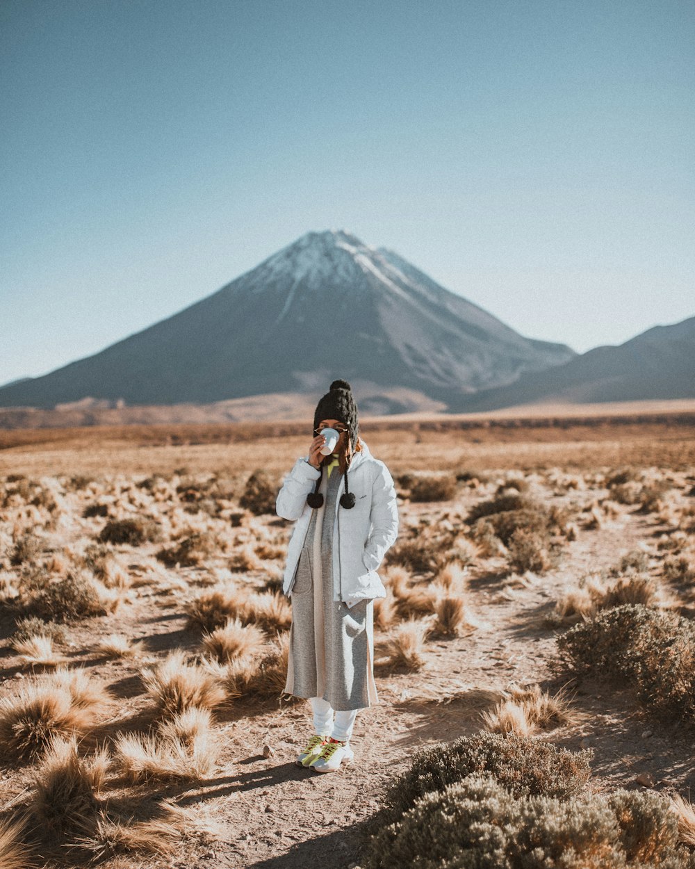 woman in white long sleeve dress standing on brown grass field during daytime