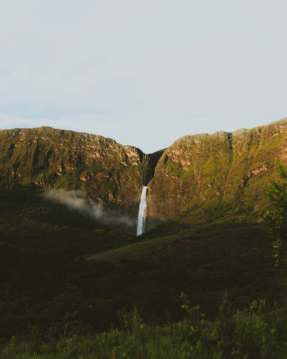 waterfalls on green grass field during daytime