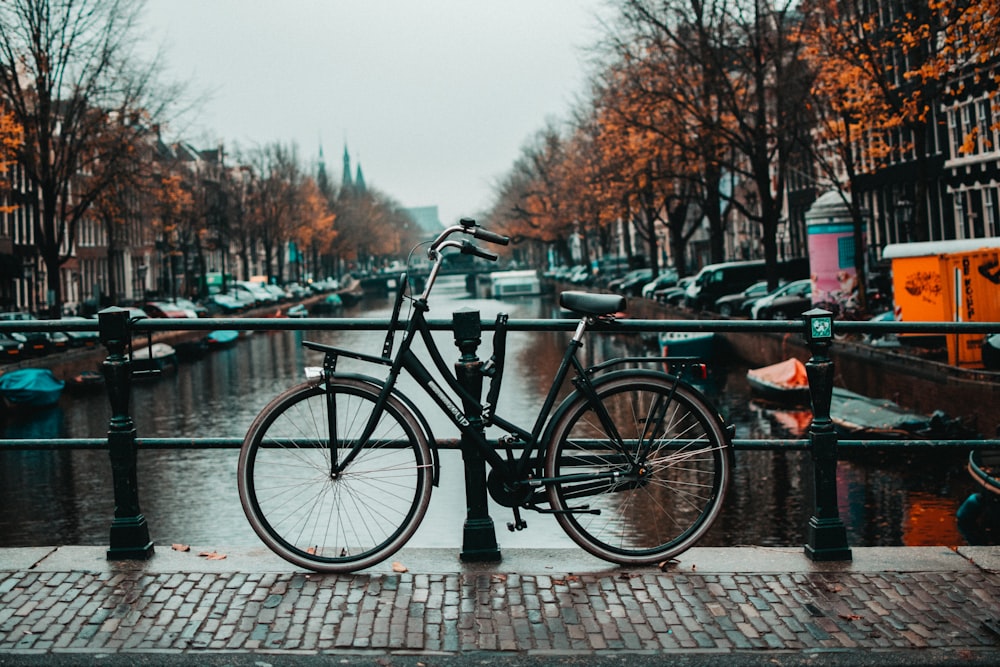 black bicycle parked beside black metal fence during daytime