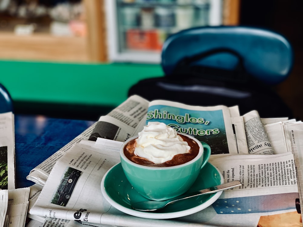 white ceramic teacup on white newspaper