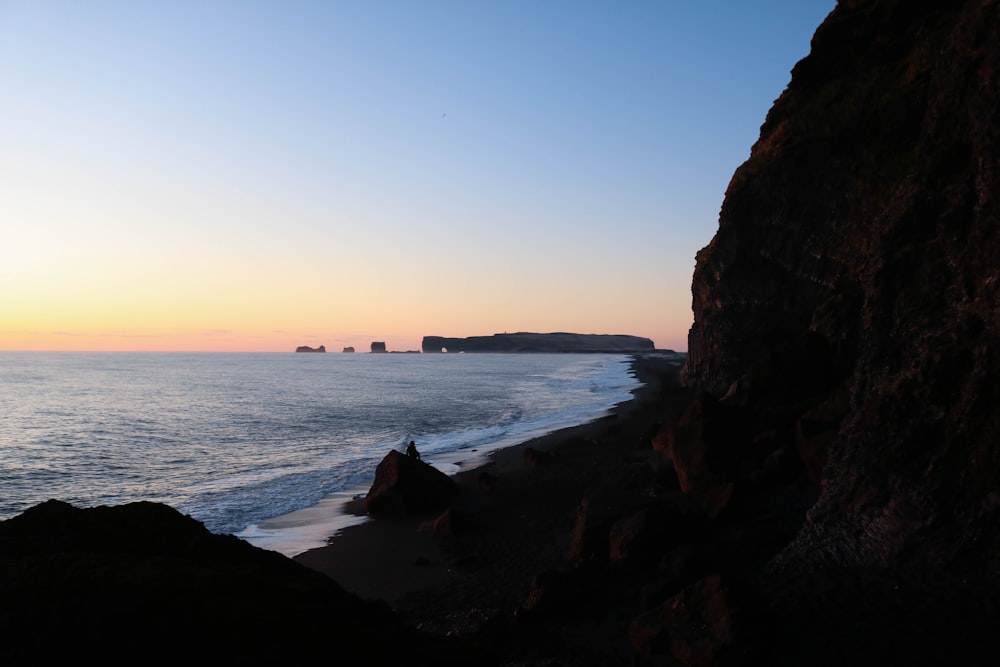 brown rock formation near body of water during daytime