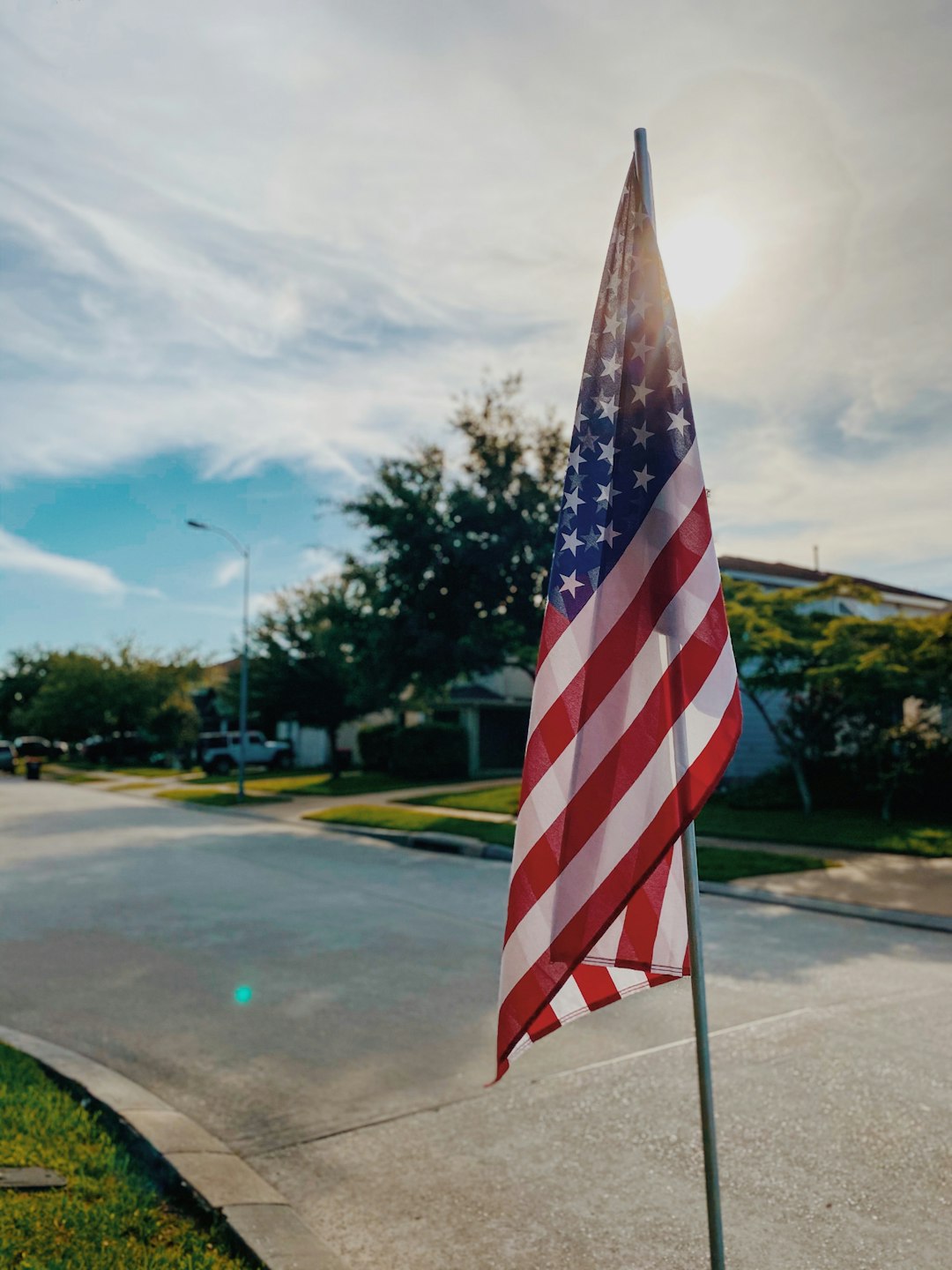 us a flag on gray asphalt road during daytime