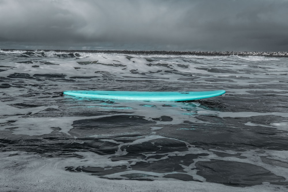 red surfboard on beach shore during daytime