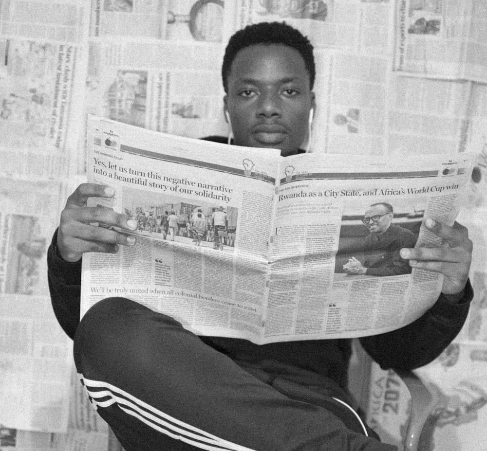 woman in black and white long sleeve shirt holding newspaper