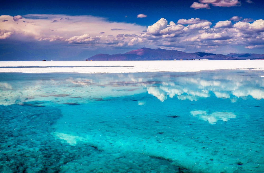 blue sea under blue sky and white clouds during daytime