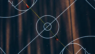 Close-up of a basketball training session with cones and a coach giving instructions on an outdoor court.