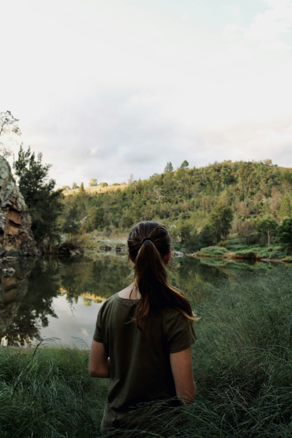 woman in brown shirt standing near lake during daytime