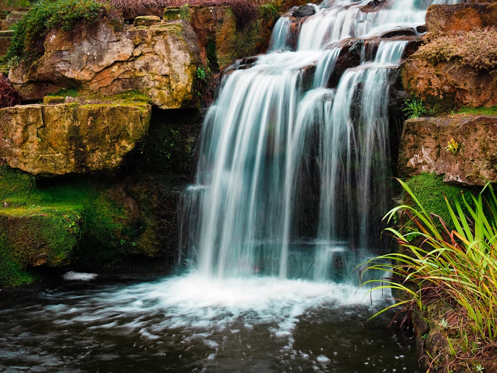 water falls on brown rocky mountain