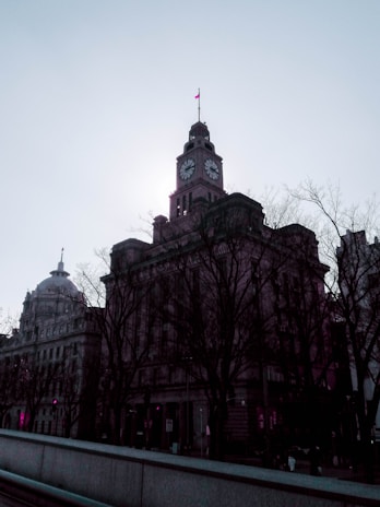 A quiet moment captured of an old clock tower silhouetted against a dusky sky.