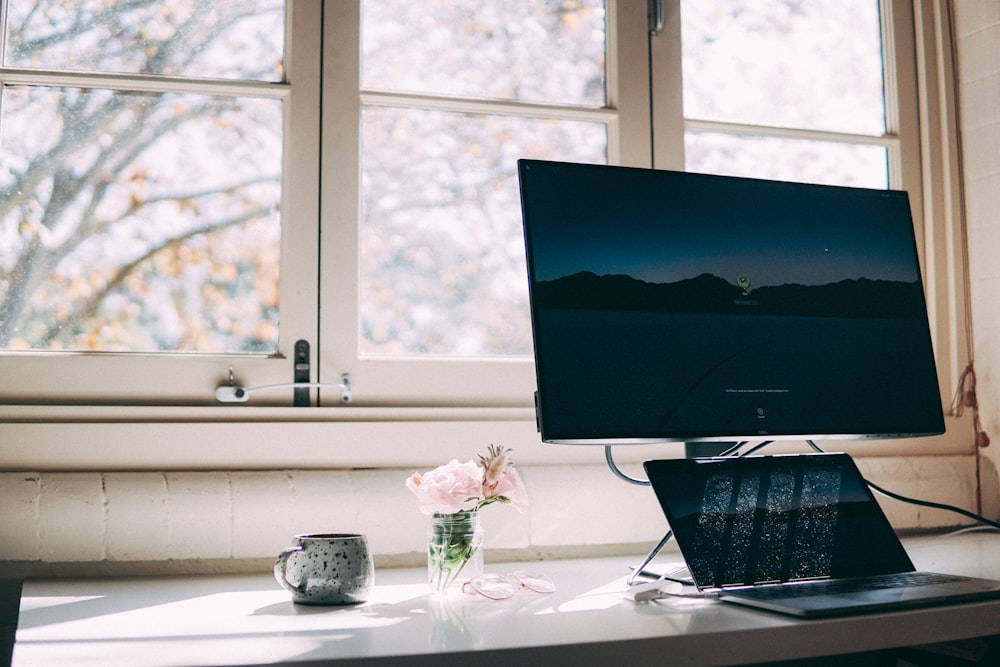 black flat screen computer monitor on white desk