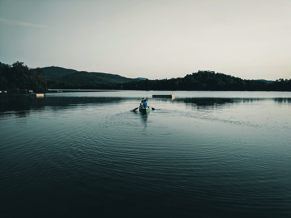 2 personnes à bord d’un bateau sur le lac pendant la journée