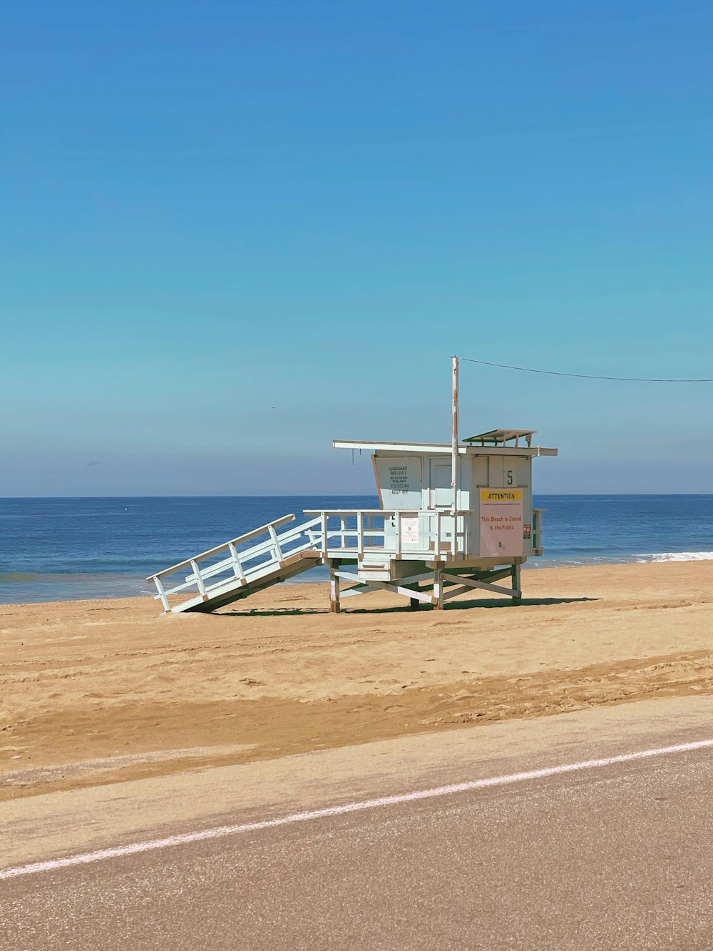 white wooden lifeguard house on beach shore during daytime