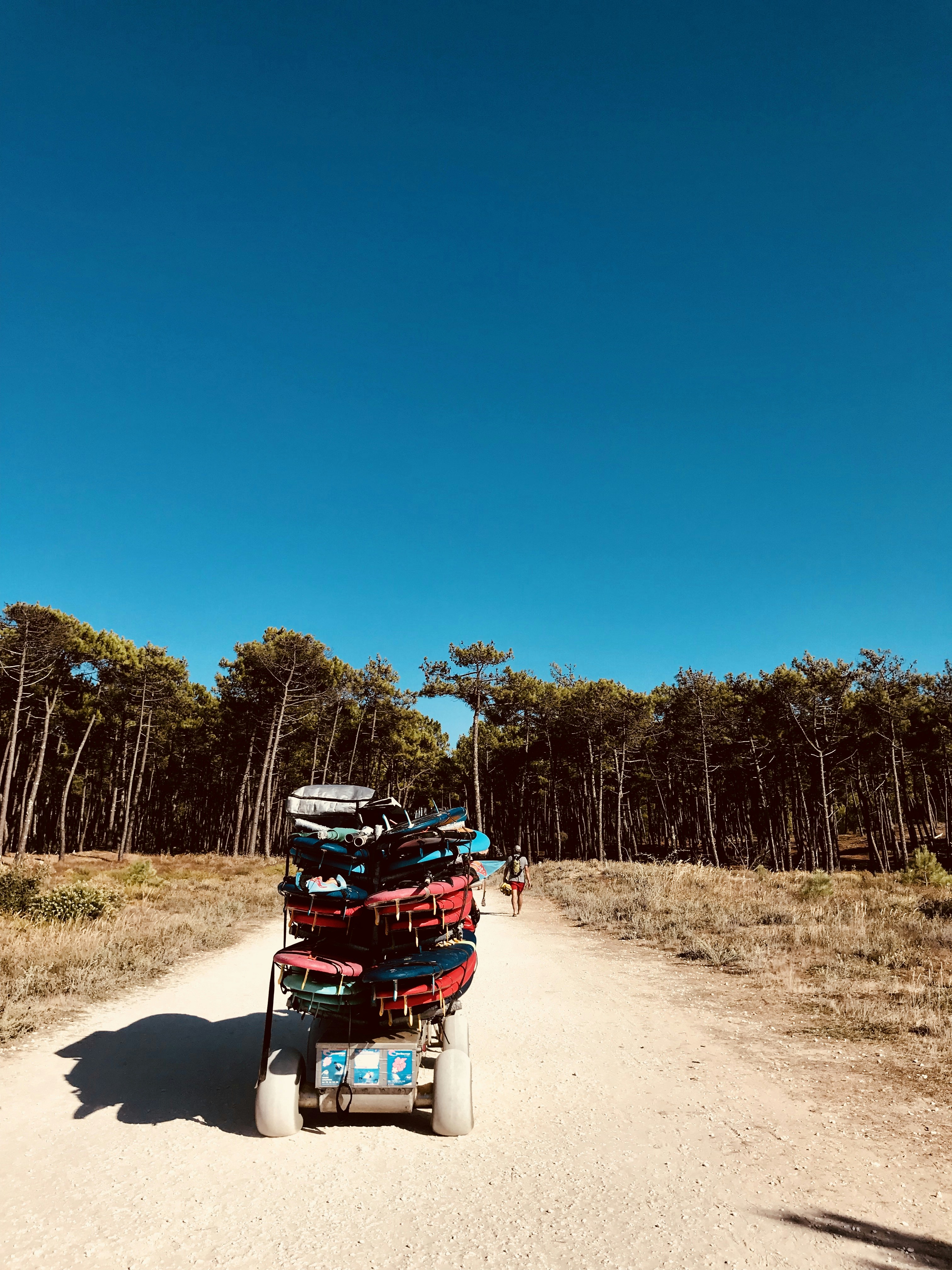 red and black motorcycle on dirt road during daytime
