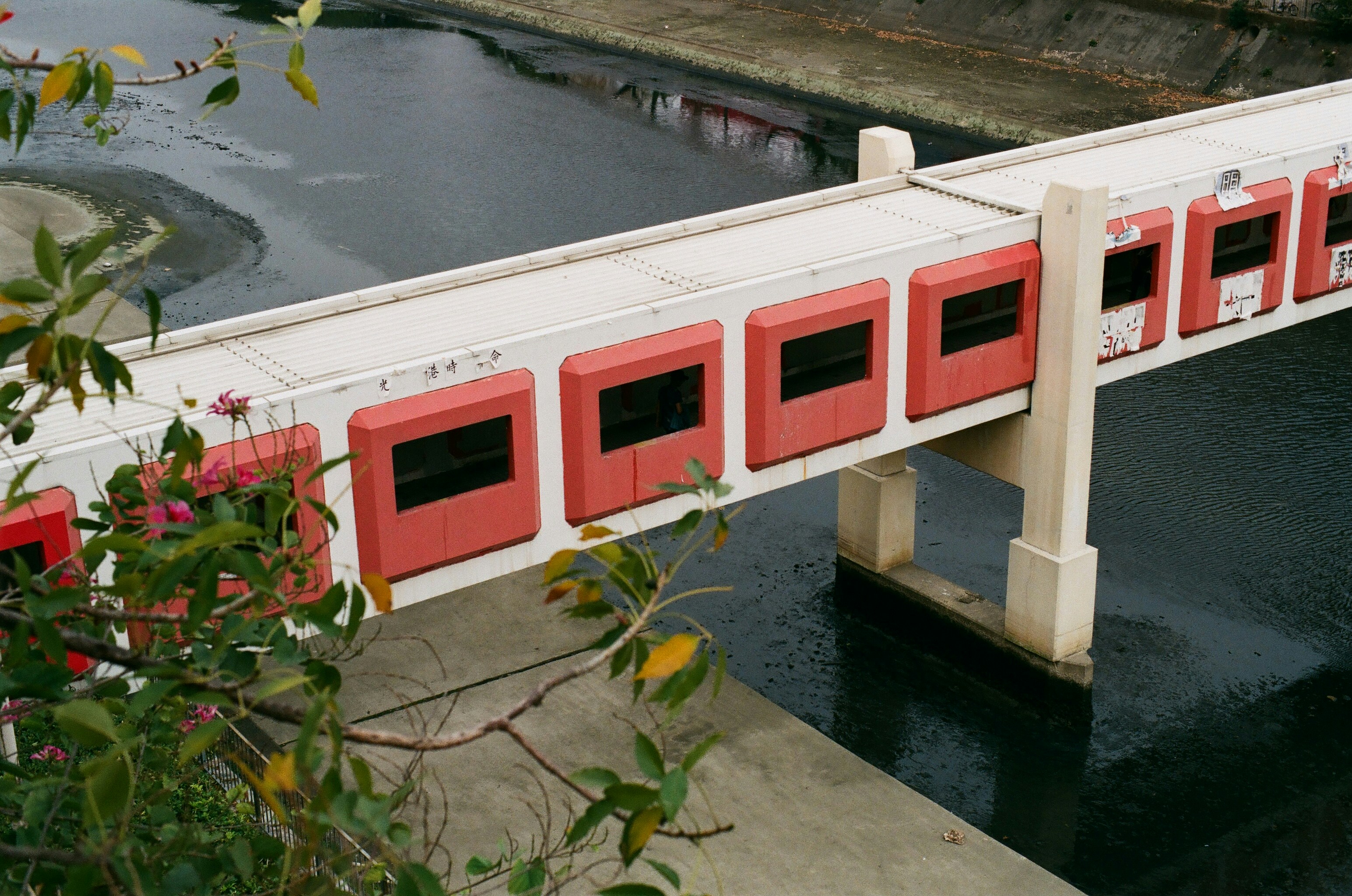 white and red concrete building beside body of water