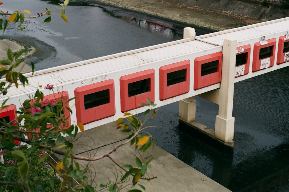 white and red concrete building beside body of water