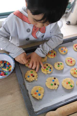 person holding white ceramic plate with cookies