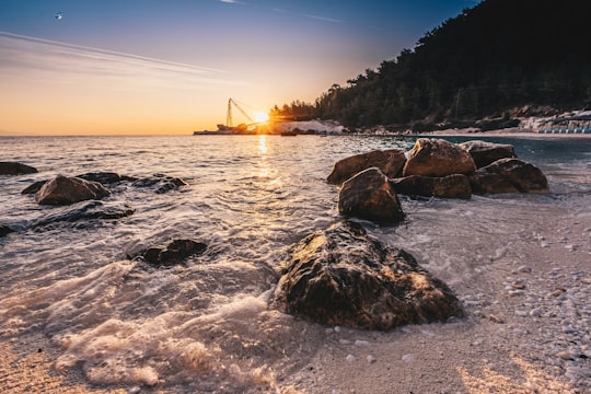 brown rock formation on sea during daytime in Thassos Greece