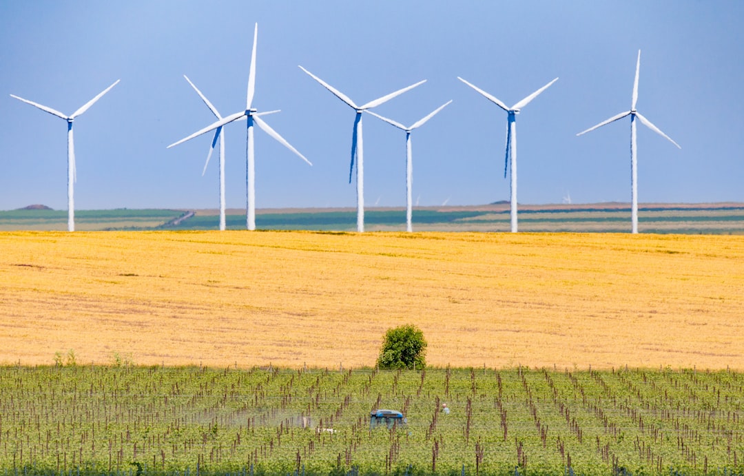 white wind turbines on brown field during daytime