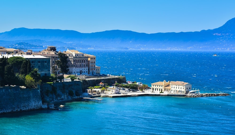 edificio in cemento bianco e marrone vicino allo specchio d'acqua durante il giorno