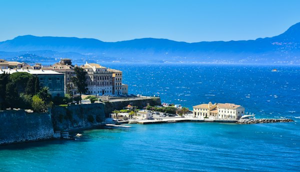 White and brown concrete building near body of water during daytime — Corfu, Greece