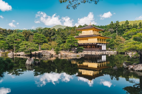 brown and white house near lake during daytime in Kinkaku-ji Japan