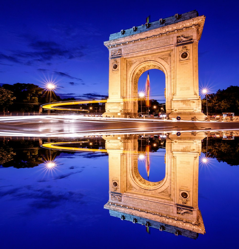 arco de concreto marrom perto do corpo de água durante o dia