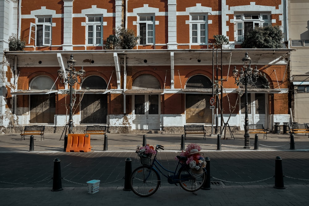 black bicycle parked beside brown concrete building during daytime