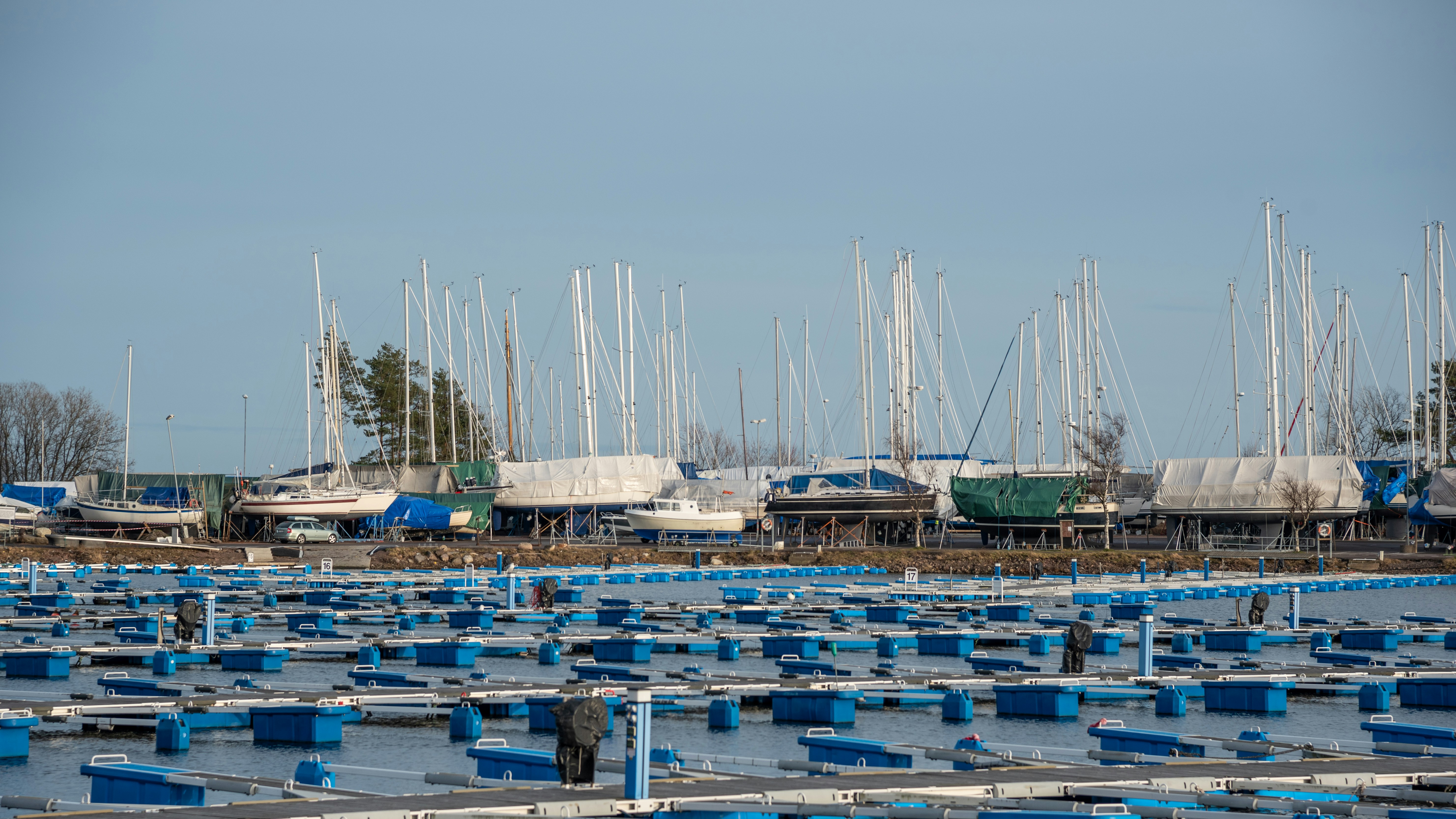 white and blue boats on sea dock during daytime, Vallø marina in Tønsberg in the springtime before most of the boats are in the water. 