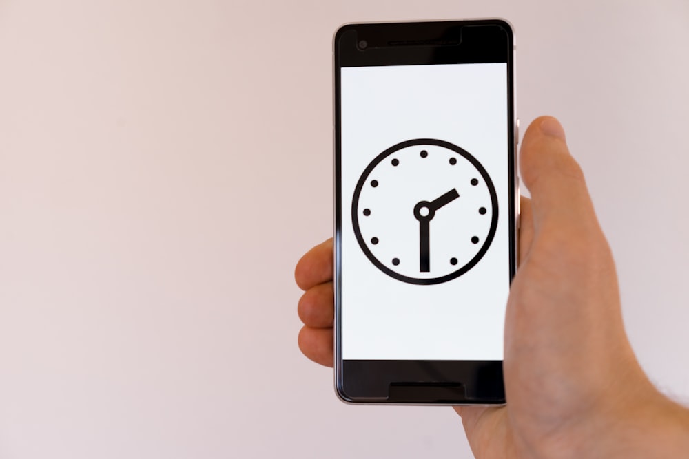 Persona sosteniendo un teléfono inteligente Android negro