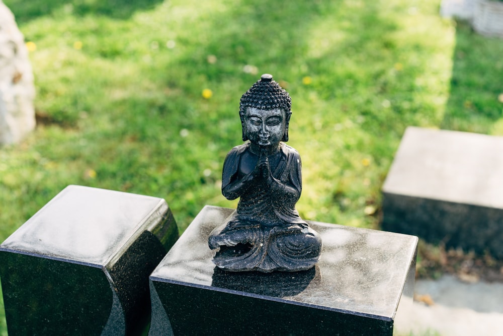 black concrete statue on gray concrete bench