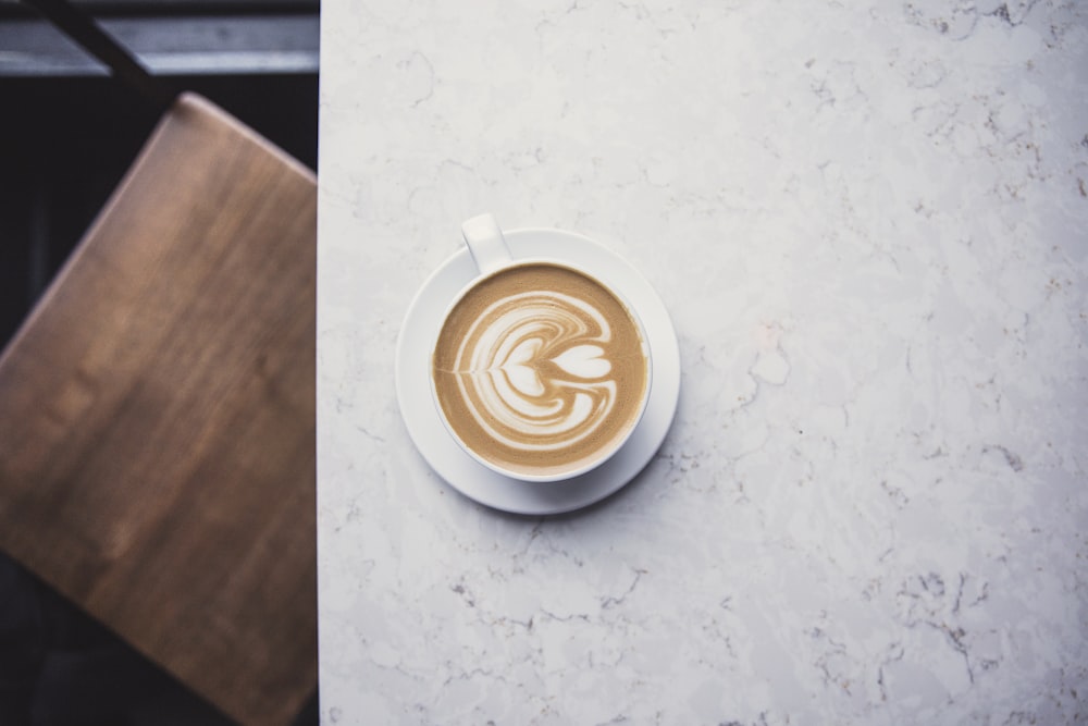 white ceramic cup with brown liquid on white ceramic saucer